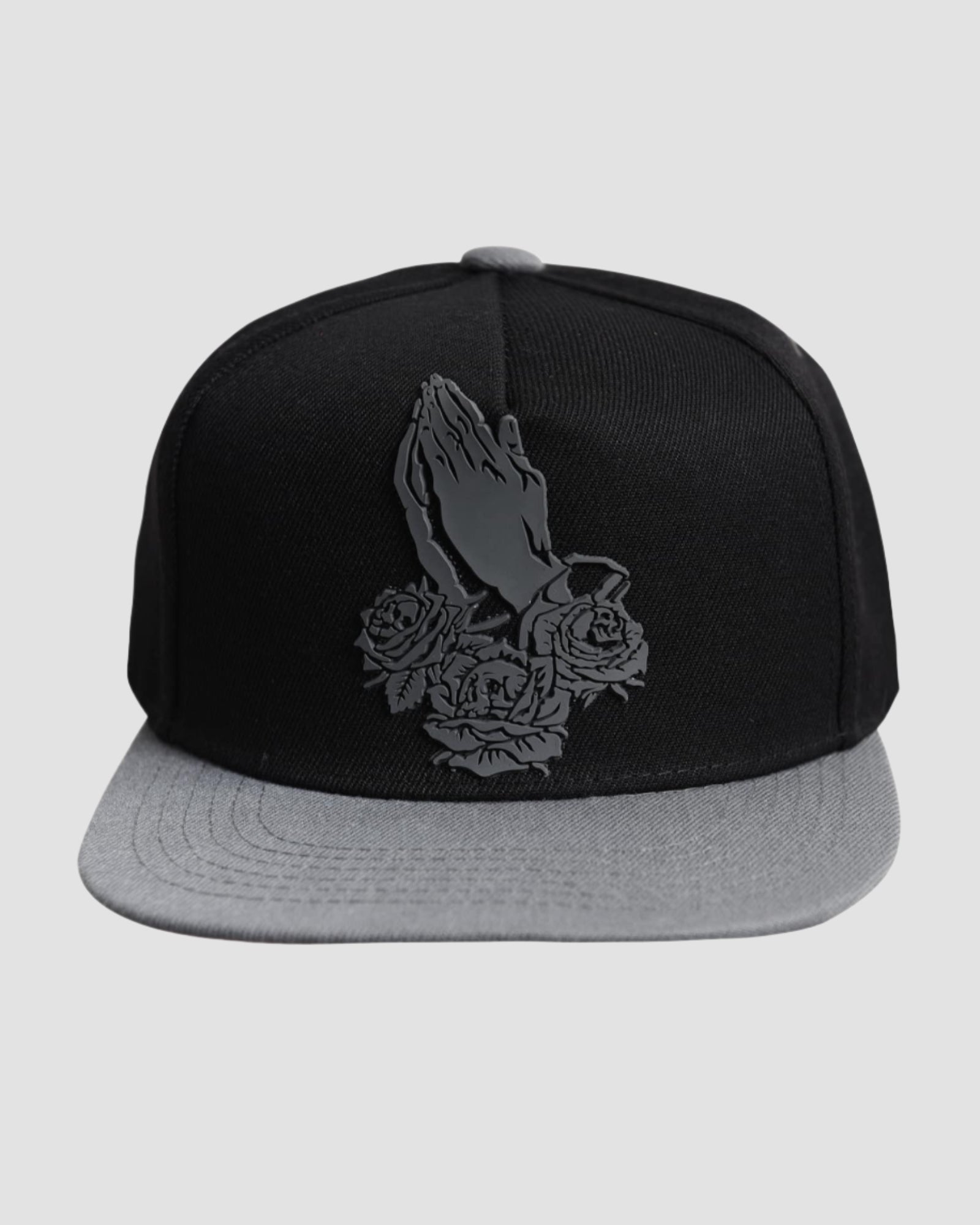 Front view of the ‘Men’s Prayer Skull Roses Snapback’ by Ring of Fire Clothing in Black Grey color, showcasing the unique design of prayer hands with roses and skulls inside the roses, in one size.