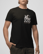 Person wearing a black t-shirt with 'Trust God' text on a plain background
