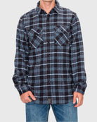 Person wearing a black and blue plaid shirt on a gray background