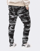 Infantry jogger pants in black camo shown on model from back view with cargo pockets and elastic cuffs
