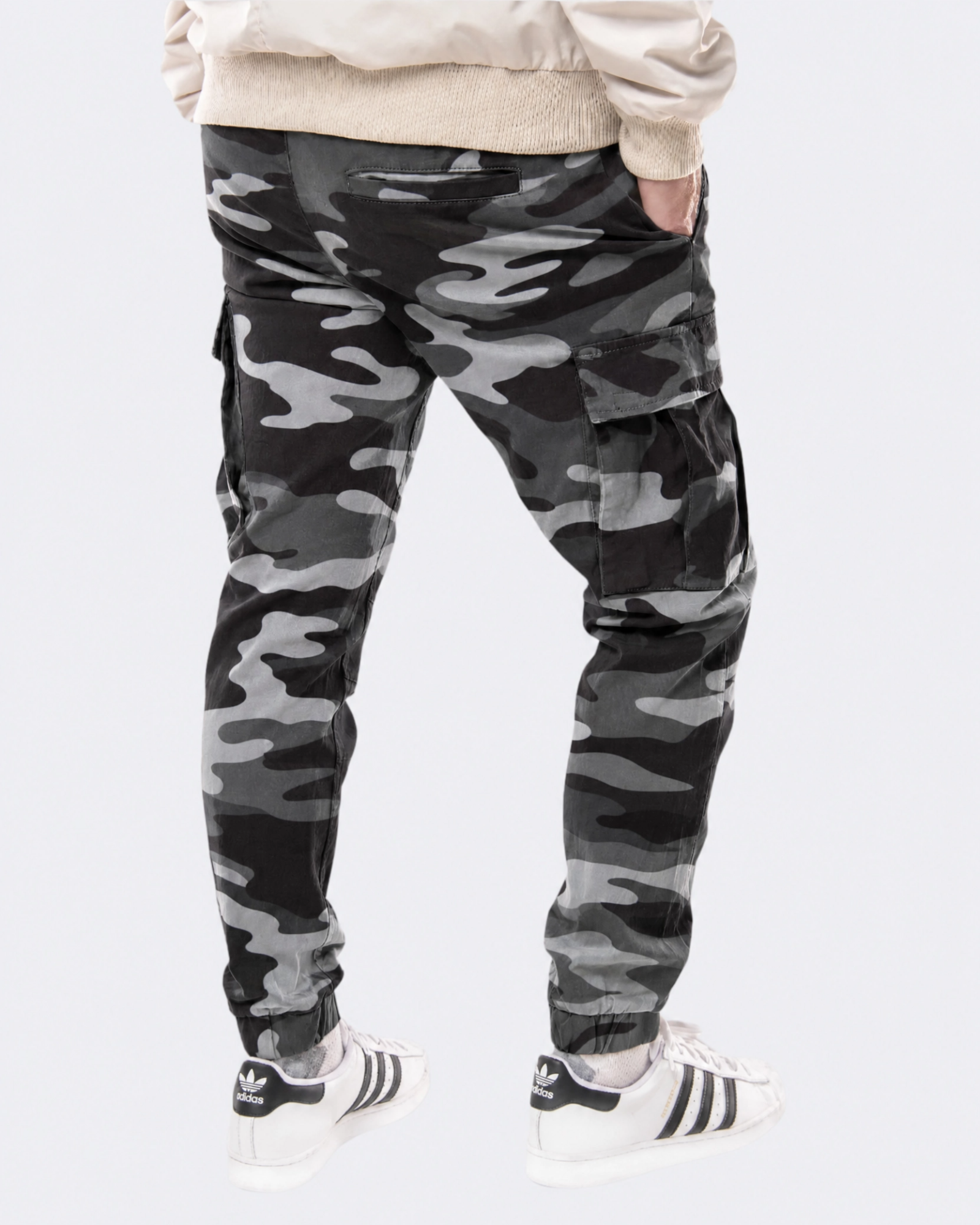 Infantry jogger pants in black camo shown on model from back view with cargo pockets and elastic cuffs