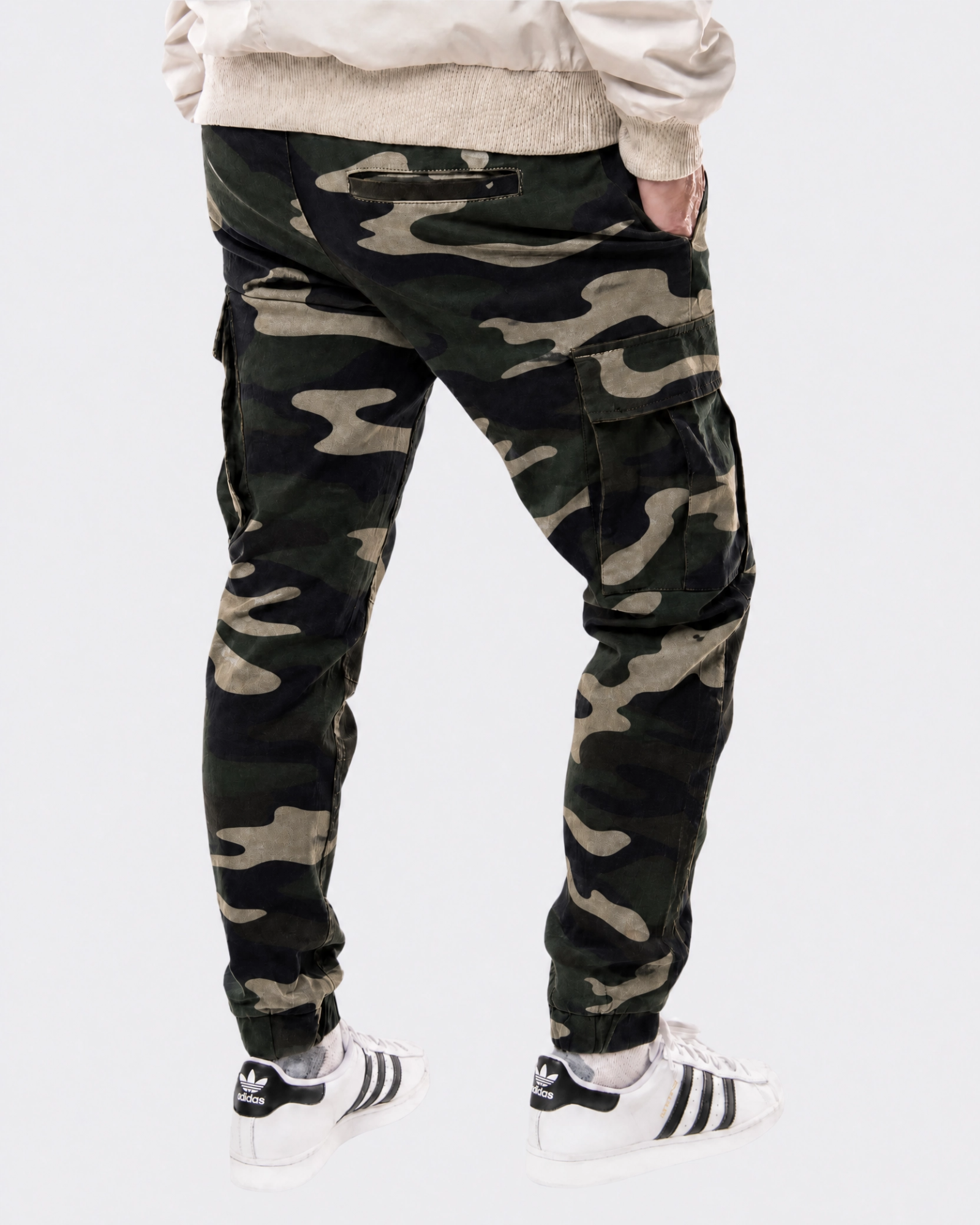 Infantry jogger pants in green camo shown on model from back view with cargo pockets and elastic cuffs