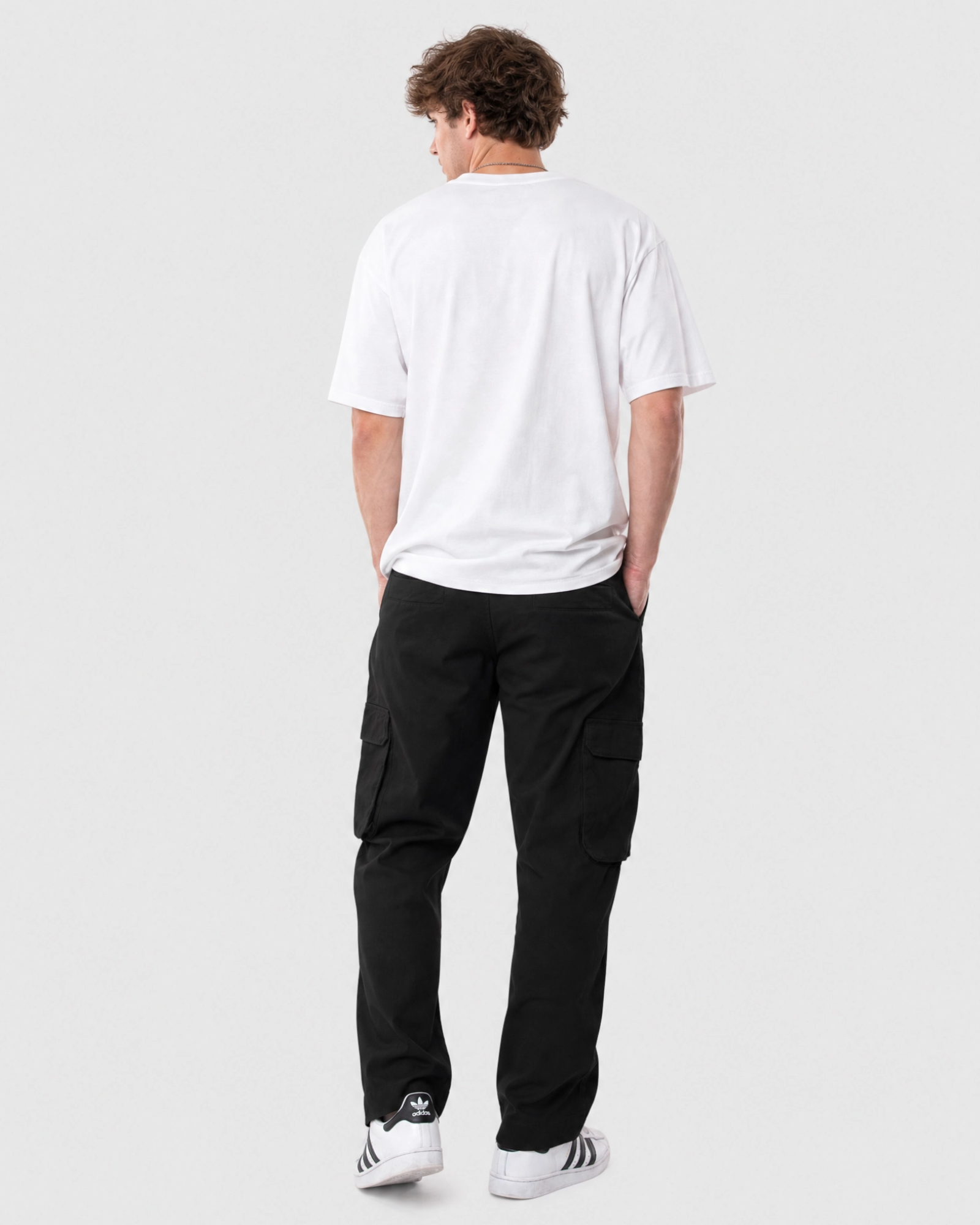 Model wearing Ledger black cargo pants with a relaxed fit white tee back view