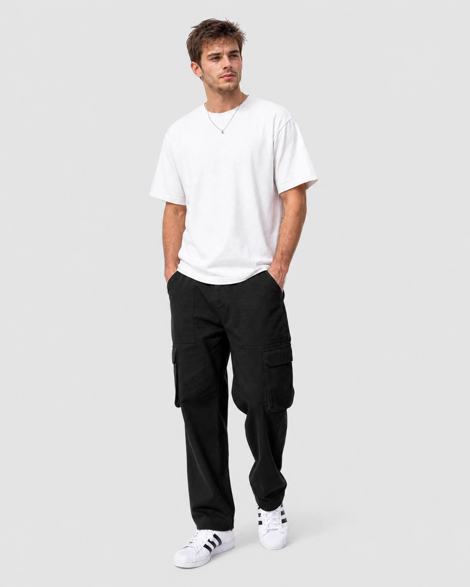 Model wearing Ledger black cargo pants with a relaxed fit white tee front view