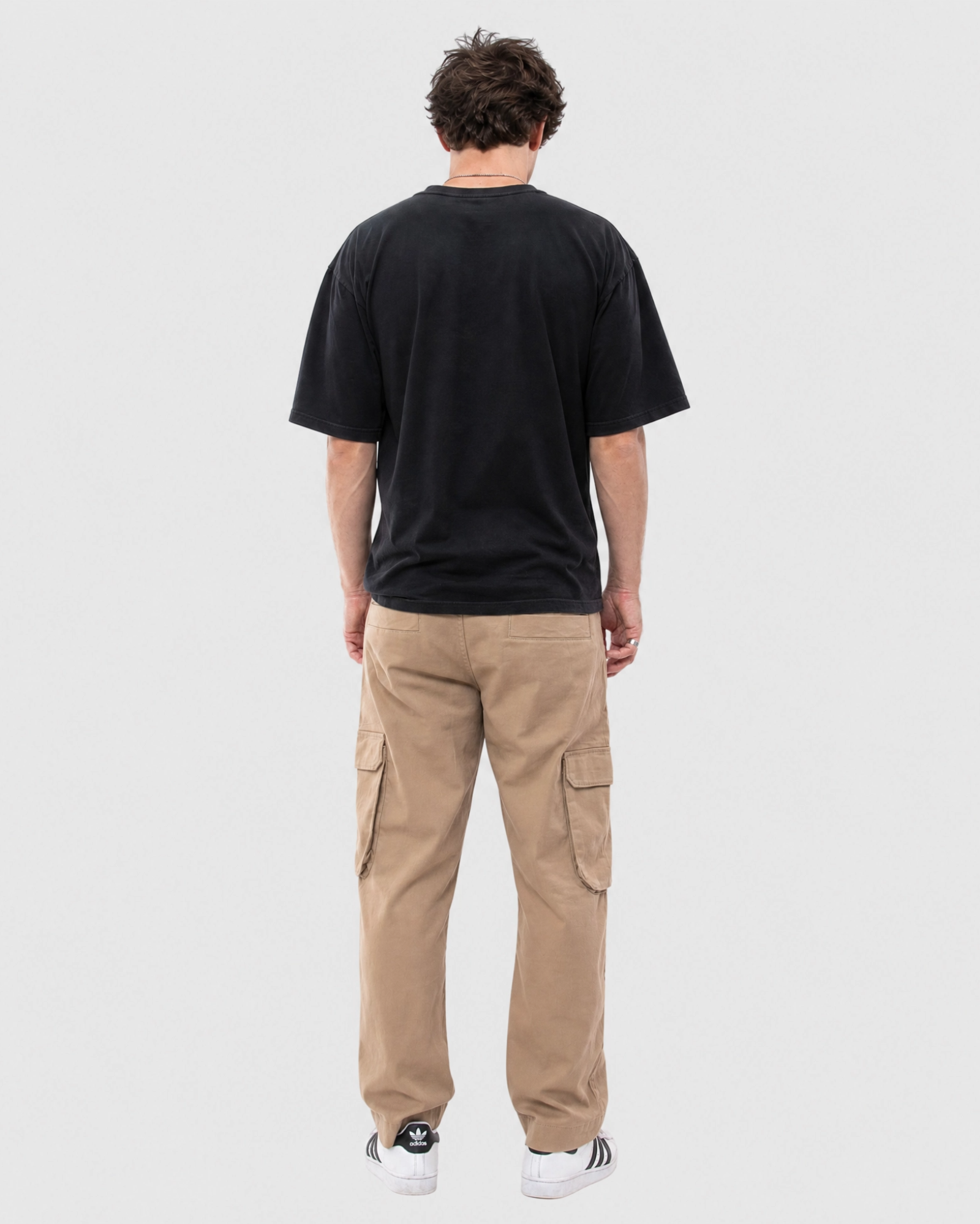 Model wearing Ledger khaki cargo pants with a relaxed fit tee back view